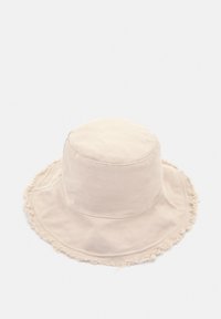 Beżowy bawełniany kapelusz typu bucket z frędzlami na brzegu, gładką teksturą, okrągłą koroną oraz casualowym fasonem odpowiednim do użytku na zewnątrz.