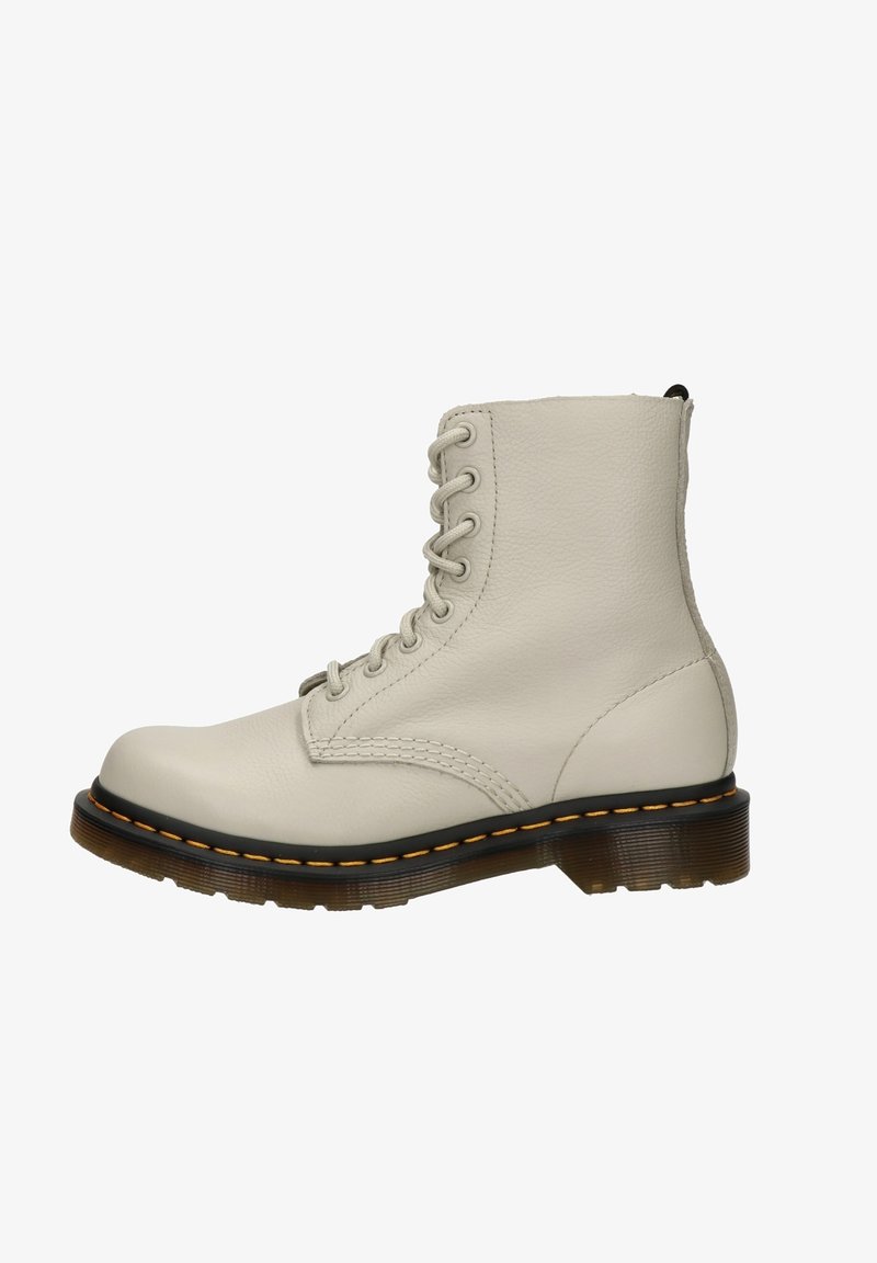 Bottine montante en cuir blanc cassé avec semelle noire et coutures jaunes, dotée d'une semelle robuste et d'une languette à l'arrière.