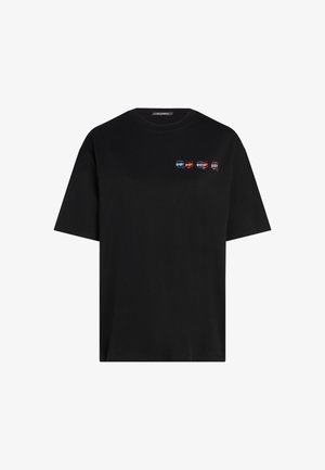 Melna kokvilnas t-kreklu ar apaļu kaklu, īsām piedurknēm un četriem maziem, krāsainiem automobiļu grafikas attēliem uz priekšpuses.