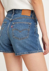 Jeansshorts i ljusblått med hög midja, bakfickor och förstärkt sömnad. Har en läderetikett på midjebandet.