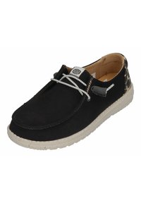 Black canvas slip-on shoe with a textured surface, white laces, and a speckled rubber sole. Features a leopard print accent at the heel.