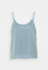 Ljust blå spetstop i mjukt tyg. Har tunna justerbara axelremmar och en avslappnad passform. Slät textur genom hela plagget.