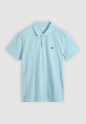 Lyseblå polo t-shirt med korte ærmer, tre knapper og lille rødt Levi’s logo på venstre bryst mod hvid baggrund.