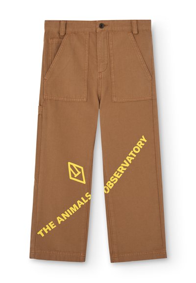 Pantalons en coton marron avec deux grandes poches avant, présentant des lettres jaunes et un détail de logo sur la jambe gauche.