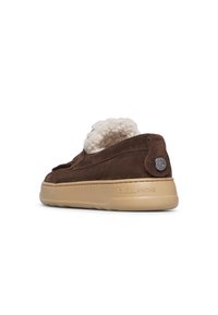 Brown suede sneaker with beige sole and textured, fluffy lining. Features a round metal logo on heel and stitched detailing along the sides.