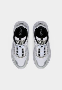 Ζευγάρι λευκών και γκρι αθλητικών παπουτσιών FILA με σχέδια φίδι, μαύρο εσωτερικό και λευκά κορδόνια, φωτογραφημένα από πάνω σε απλό φόντο.