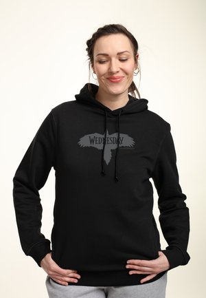 Sort hætte sweatshirt med et grafisk design af en fugl og ordet "ONSDAG" i grå på forsiden. Blødt stof, afslappet pasform.