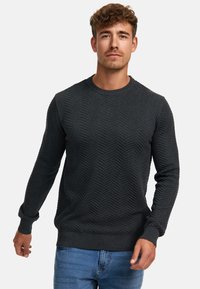Mørkegrå strikket sweater med et fiskebensmønster, ribbede manchetter og kant, rund hals og ensfarvede lange ærmer.