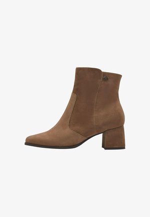 Bottine en daim marron avec un bout pointu et un talon carré. Présente un design de panneau latéral et un accent métallique décoratif à l'arrière.