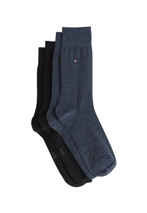 Trois paires de chaussettes : une bleu foncé avec un revers côtelé, une noire unie, et une autre noire avec une texture lisse. Chaque paire présente un logo discret.