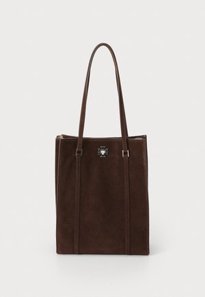 Brun ruskind tote taske med to lange håndtag, der har et emblem i sølvfarvet metal og lodrette sydetaljer på forsiden.