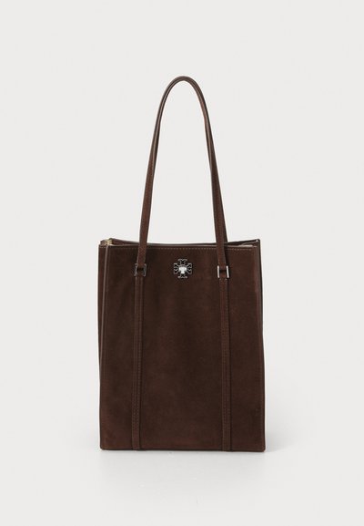 Brun ruskind tote taske med to lange håndtag, der har et emblem i sølvfarvet metal og lodrette sydetaljer på forsiden.