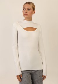 Hvid ribbet langærmet top med en høj krave og en udskæring på brystet, med tætsiddende design og blød tekstur.