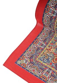 Czerwona tkanina z misternym, kolorowym wzorem paisley, otoczona ciemnym brzegiem. Miękka tekstura, kanciasty kształt, z bogatymi detalami.