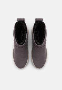 Bottines en cuir gris avec une doublure intérieure douce, un bout rond et une languette à l'arrière, dotées d'une semelle blanche contrastante.