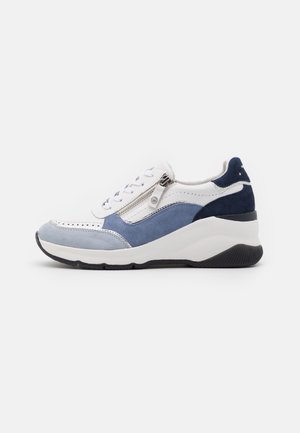Zapatilla blanca, azul claro y azul marino con cordones en la parte delantera, cremallera lateral y suela blanca gruesa con dibujo negro.