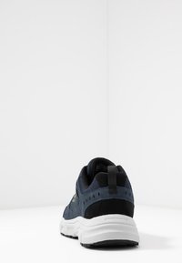 Granatowe i czarne sneakersy wykonane z siateczki i zamszu, z białą podeszwą środkową, wyściełanym kołnierzem i teksturowaną podeszwą. Logo „SKECHERS” na pięcie.
