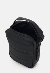 Schwarze Umhängetasche aus glattem Material, mit einem Reißverschluss oben, gepolsterten Seiten und einem einstellbaren Schultergurt. Innen mit Netzmaterial ausgekleidet.