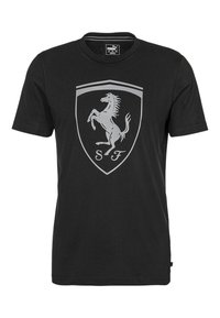 Camiseta de algodón negra con un gran logo plateado de Ferrari que presenta un caballo alzado y el texto "SF", con cuello redondo y mangas cortas.