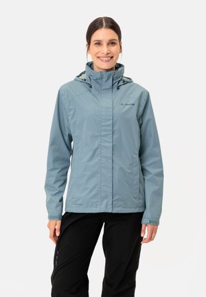 Veste imperméable bleu clair avec un col haut, une capuche réglable et un devant zippé. Un pantalon noir complète la tenue.