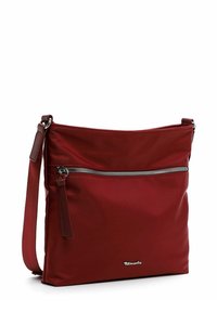 Red nylon crossbody bag with a main zip compartment and front zip pocket. Features adjustable strap and logo accent on the front.