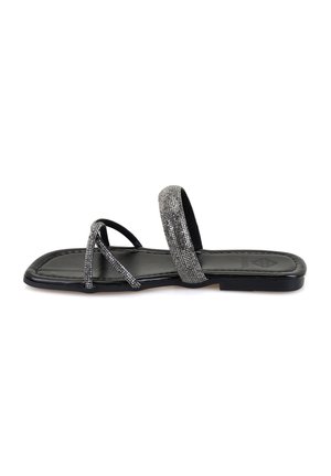 Strappy sandal featuring a black base with metallic silver accents, a flat sole, and a smooth texture. Open design with minimal coverage.