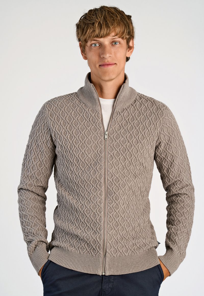 Ljusbrun zip-up-tröja med mönster av diamanter, ribbad krage och muddar, gjord av strukturerat stickat material.