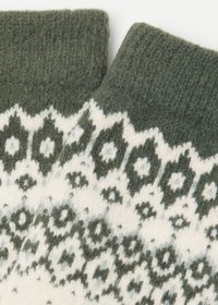 Guanti senza dita in lana con polsino verde lavorato a maglia. Presentano motivi geometrici bianchi e verde scuro. Texture morbida, aspetto caldo.