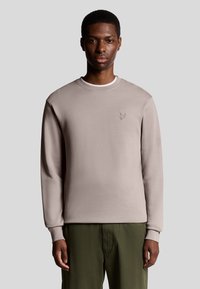 Licht taupe sweatshirt met lange mouwen, ronde hals en subtiele geborduurde logo op de borst. Zachte textuur en aangesloten ontwerp.