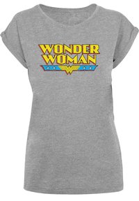 Grå t-skjorte med korte ermer som har et dristig, fargerikt "Wonder Woman"-grafikk med gul tekst og blå detaljer, satt mot den grå stoffet.