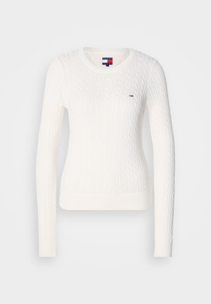 Biały sweter z dzianiny w splot warkoczowy, z długimi rękawami, okrągłym dekoltem i ściągaczem u dołu. Posiada małe logo marki na piersi.