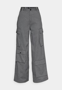 Szare spodnie cargo o szerokim kroju nogawek. Posiadają wiele kieszeni bocznych, zapięcie na guzik oraz teksturę materiału przypominającą splot diamentowy.
