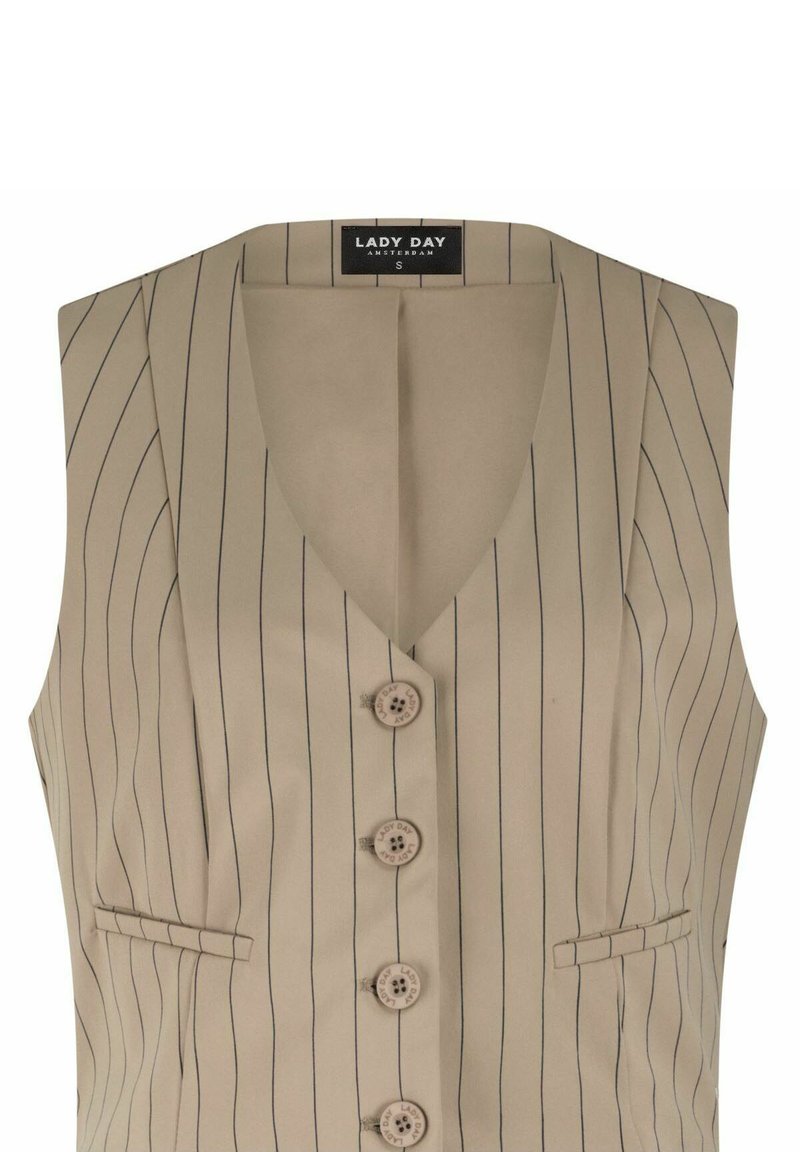 Beige mouwloos vest met dunne verticale zwarte strepen, vier knopen aan de voorkant, twee kleine paspelzakken en een "LADY DAY" label binnenin de kraag.