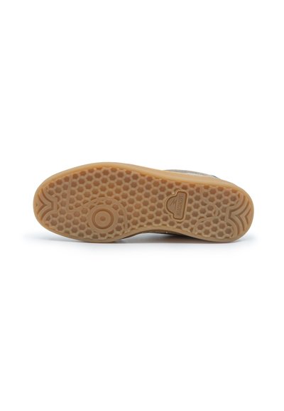 Semelle de chaussure avec motif en nid d'abeille, design circulaire antidérapant, et un petit logo rectangulaire au centre, de couleur brun clair.