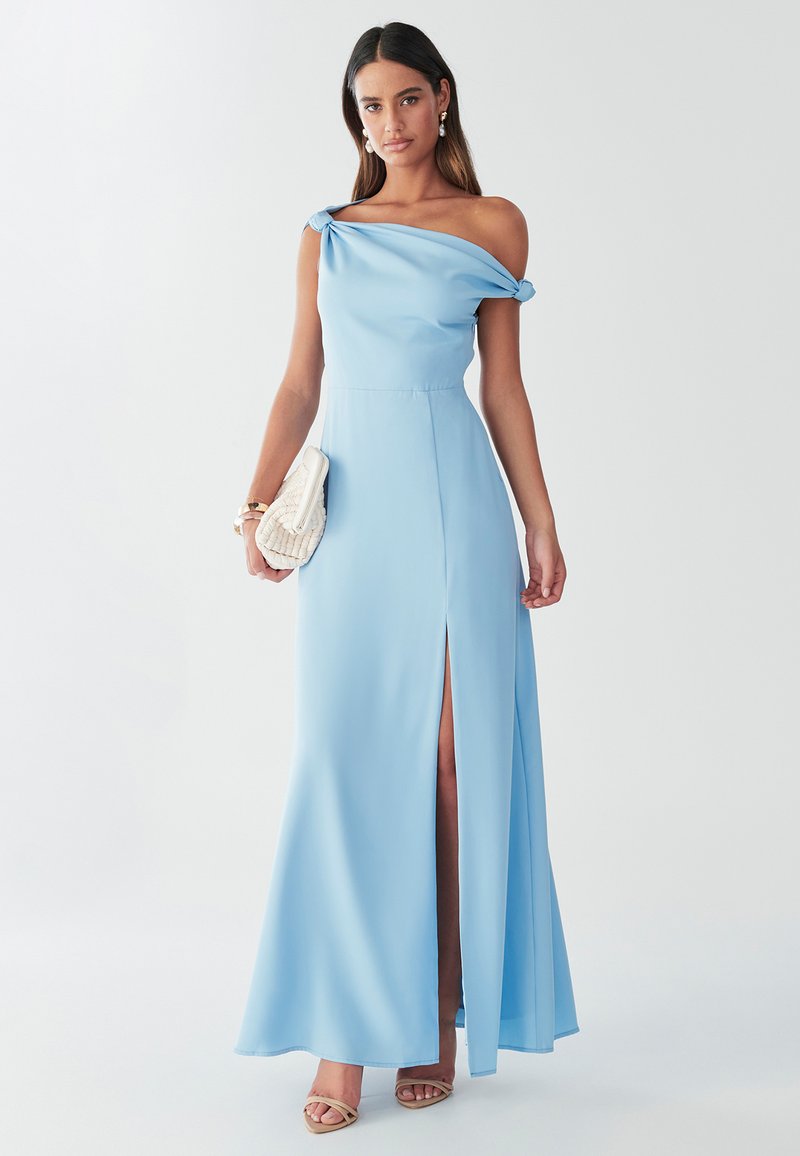 Helehall sinine õhtukleit voolava kangaga, millel on õlast paljastav disain, külgnev lõhik ja sõlmitud detail õlal.