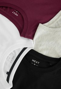 Fire T-shirts i sort, hvid, meleret grå og maroon, med rund hals og en blød bomuldsblanding, med mærkater tydeligt synlige.