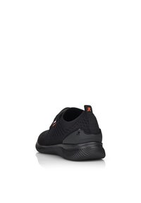 Scarpa sportiva nera con una tomaia in mesh traspirante, suola flessibile e dettagli testurizzati. Include un'etichetta per facilitare l'indossamento.