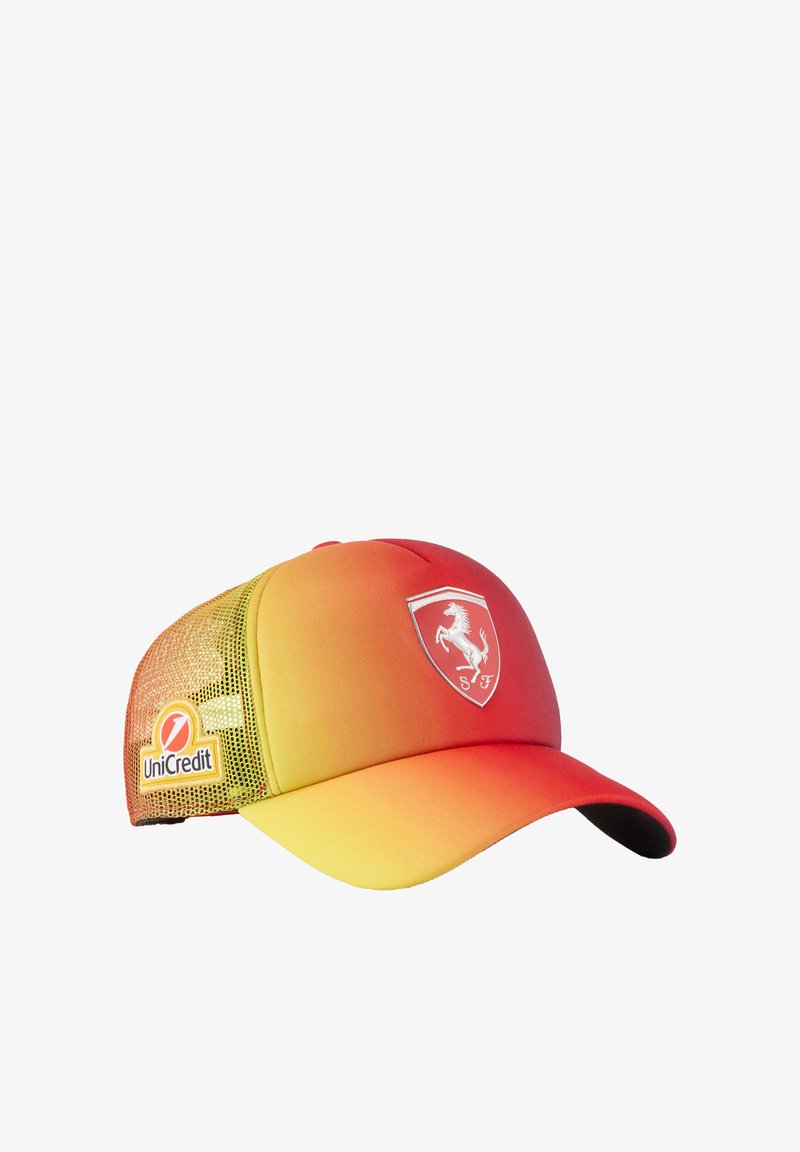 Czapka w gradientzie od czerwonego do żółtego z zakrzywionym daszkiem, siateczkowym panelem z boku oraz białym logo Ferrari z przodu. Zawiera branding UniCredit.
