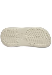 Semelle de chaussure, caoutchouc beige clair avec une surface texturée présentant des motifs en zigzag et en pyramide pour l'adhérence, forme arrondie et design flexible.