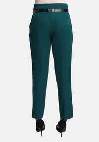 Pantalons ajustés teal avec une texture lisse, dotés d'une ceinture noire et de poches latérales. Design à jambe droite avec une finition soignée.