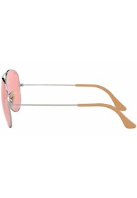 Occhiali da sole in metallo con grandi lenti rotonde rosa, montatura argentata e punte in gomma beige per comfort e presa.