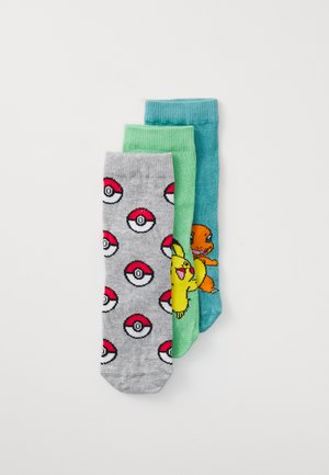 Tre paia di calze: grigie con Poké Balls, verdi con un personaggio dei cartoni animati e azzurro chiaro con una piccola creatura arancione. Materiale in cotone, texture a coste.