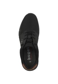 Svart sportskor med en texturerad ovandel, snörningsdesign och dämpad innersula. Den har en brun accent nära sulan.