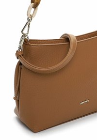 Sac à main en cuir marron à finition texturée, présentant une forme fine, une poignée incurvée et un détail logo doré sur le devant.