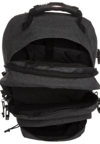 Zaino in tessuto nero con chiusura a zip, più scomparti, maniglia imbottita e spallacci regolabili, con una finitura texture.