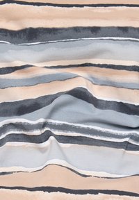 Weicher Stoff mit horizontalen unregelmäßigen Streifen in Beige-, Grau-, Schwarz- und Weißtönen, der sanfte Falten und Textur zeigt.