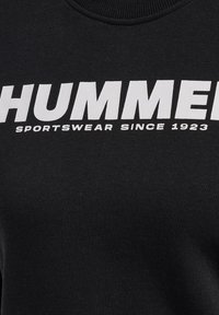 Sudadera negra con cuello acanalado que presenta un gran texto blanco que dice "HUMMER" y "SPORTSWEAR SINCE 1923". Textura de tela suave.