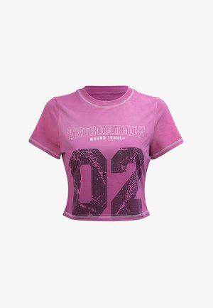 Kurzes, pinkes, cropped T-Shirt mit Kontrastnähten, das ein grafisches "TRUE RELIGION"-Logo und einen großen schwarzen "02"-Druck auf der Vorderseite zeigt.