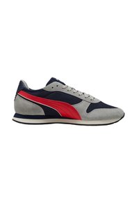 Zapatilla deportiva gris y azul marino con acentos rojos, materiales de ante y malla, diseño con cordones y una suela de goma blanca minimalista.