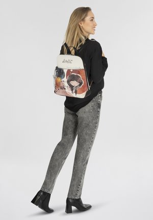 Rucksack mit weißem Oberteil, featuring ein illustriertes Design in warmen Farben, ein Mädchen mit einem dunklen Bob-Haarschnitt, und dem Text „Tanze mit einem“ in Schreibschrift.